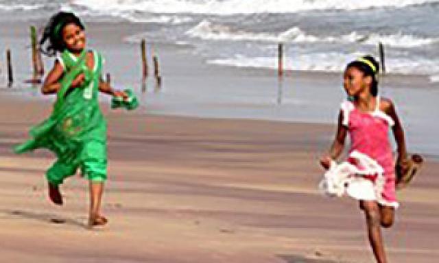 Two children running on the beach