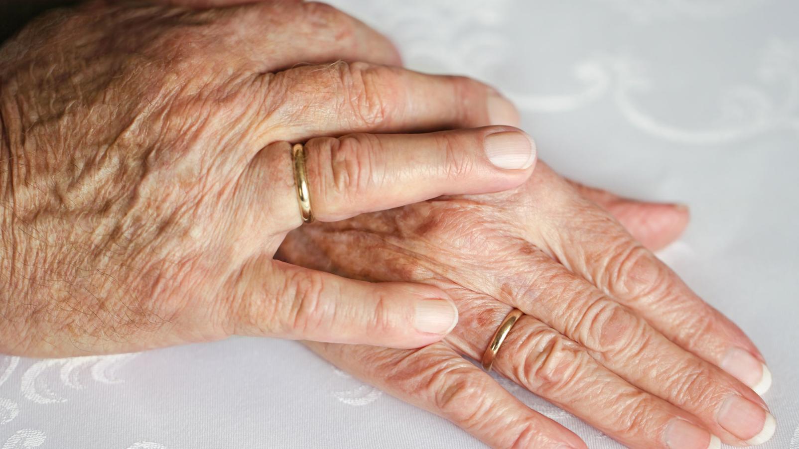 Close up photo of a hand on another hand showing care