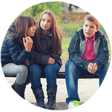Three adolescents sitting on a bench in a bench