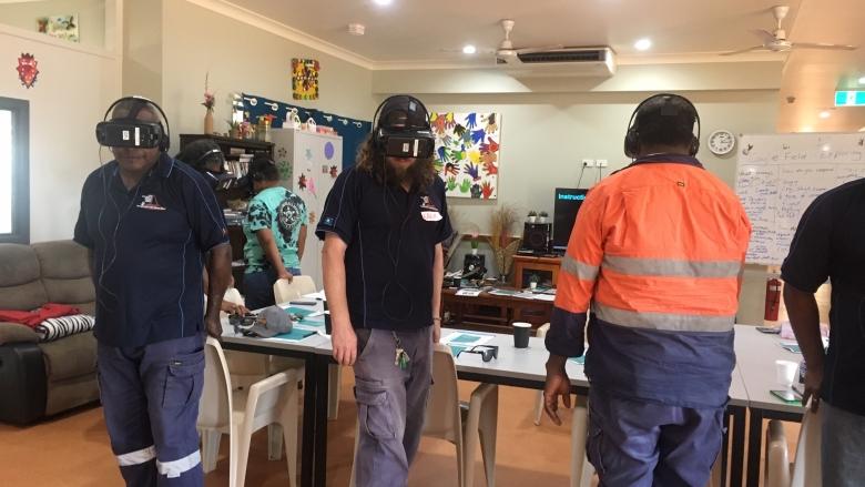 Three males wearing headsets and undertaking a dementia virtual reality experience. 