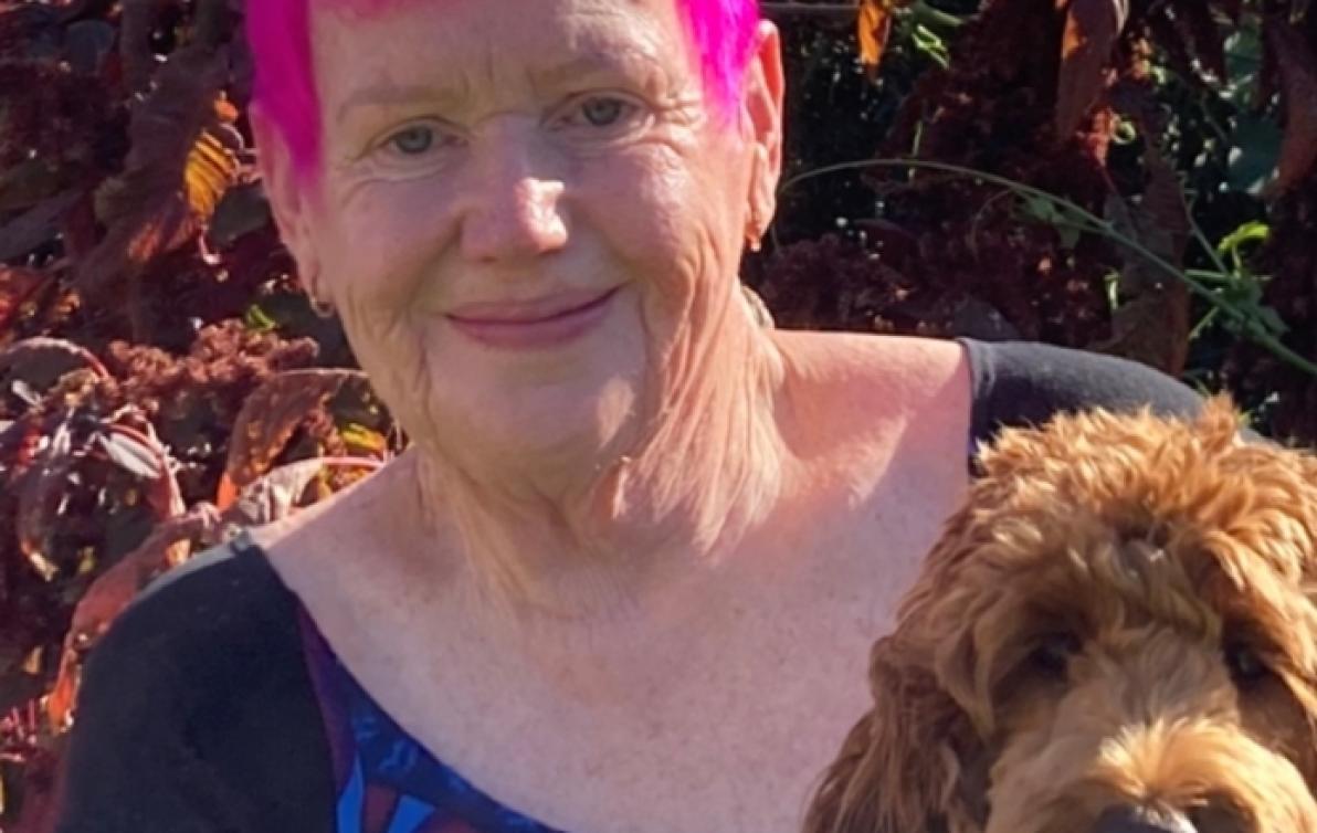Dementia Advocate Gwenda Darling holding her dog in the sunshine..