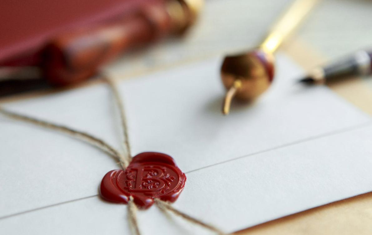 An official looking envelopewith a red wax seal and string.