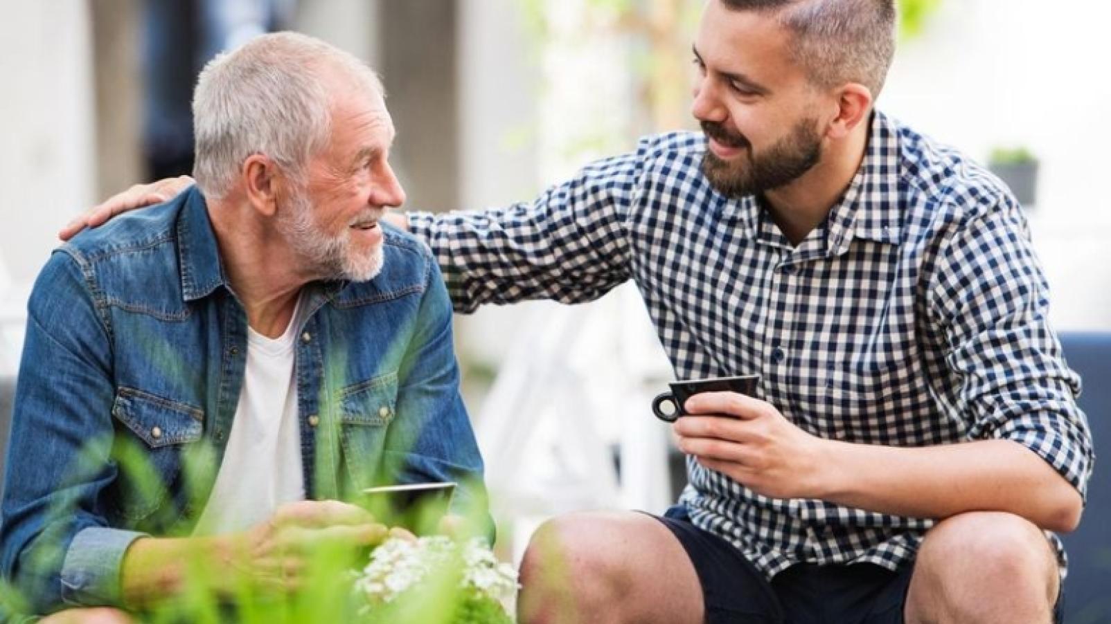 carer chatting to elderly man in the backyard