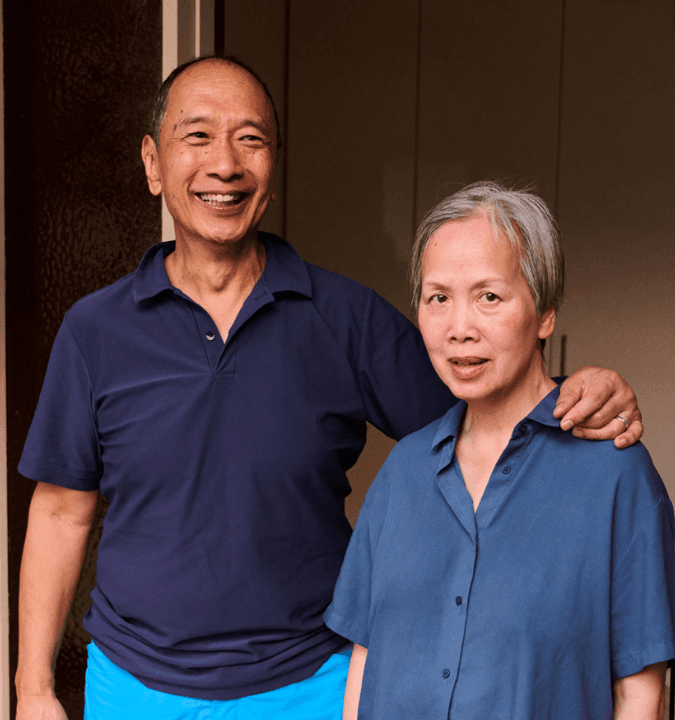 Danny and his wife Resina, standing outside together and looking at the camera.